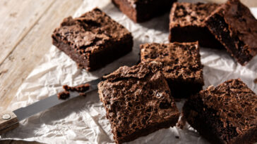 Homemade pieces of dark chocolate brownies on rustic wooden table
