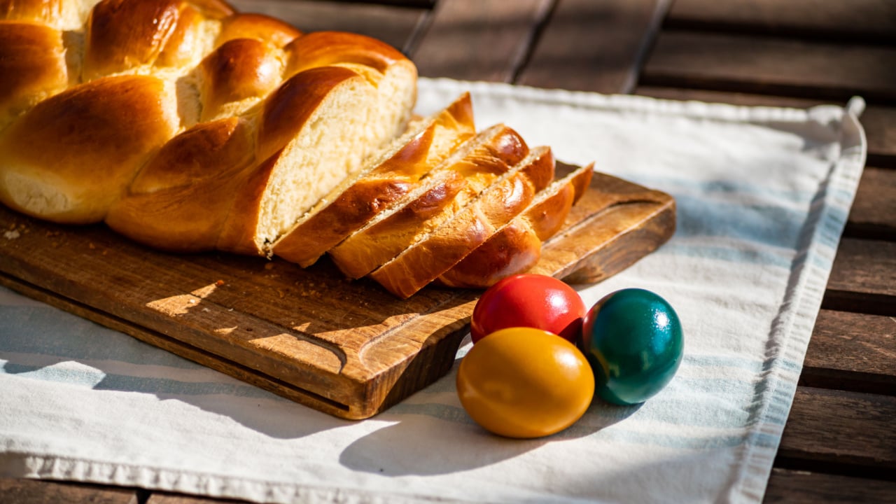 Easter breakfast, Striezel, yeast wreath, plait on a bread board, with colored eggs.