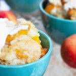 Fresh peach cobbler served with vanilla ice cream.