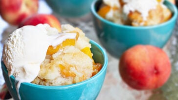 Fresh peach cobbler served with vanilla ice cream.