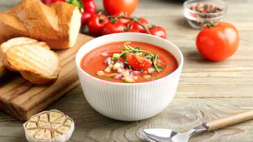 Bowl with tasty gazpacho on wooden background