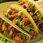 Homemade Ground Beef Tacos with Lettuce, Tomato, and Cheese.