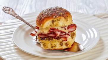 Ham and Cheese Slider with Hawaiian Roll on white plate on white wood table