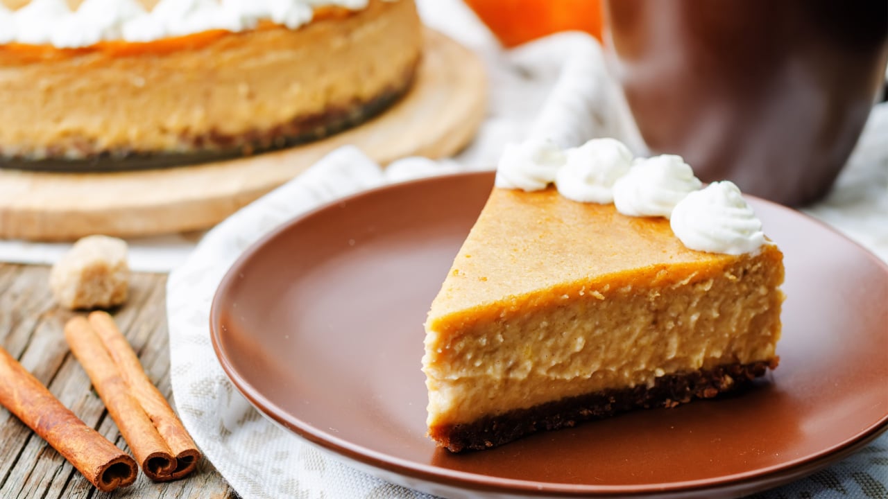 pumpkin cheesecake decorated with whipped cream.