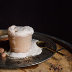 overflowing root beer float style drink cocktail with nutmeg, cinnamon.