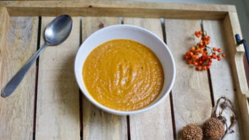 Simple homemade roasted butternut squash soup on rustic wood tray