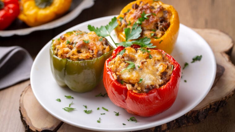 Stuffed peppers in a baking dish on a blue wooden table